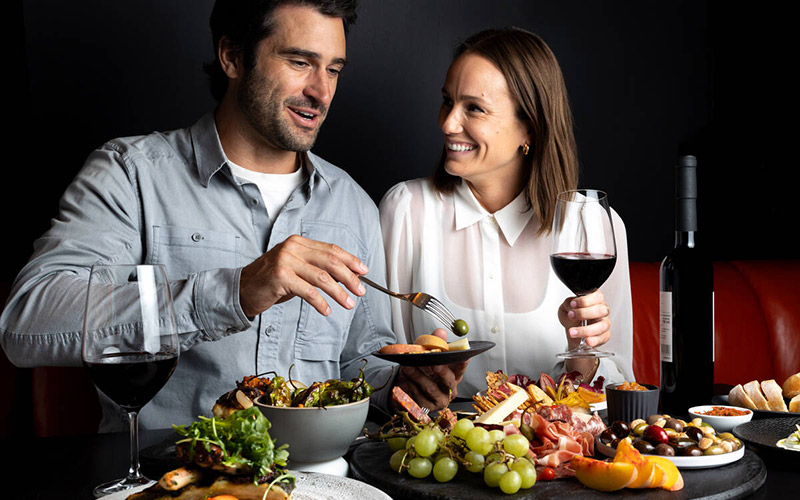 Two people enjoying food and wine at a Cornucopia restaurant event in Whistler