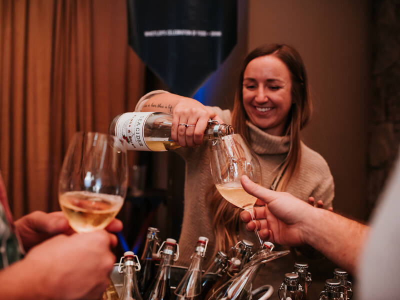 A Cornucopia Whistler volunteer pouring cider at an event