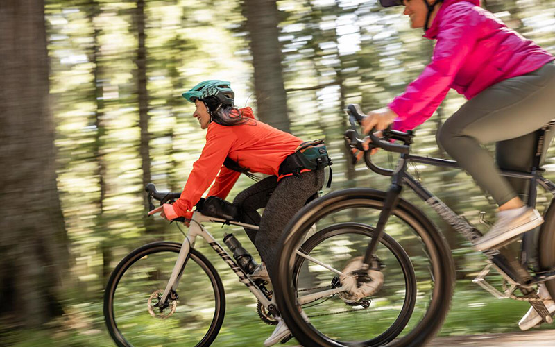Two people riding the Valley Trail on bikes in spring in Whistler, British Columbia